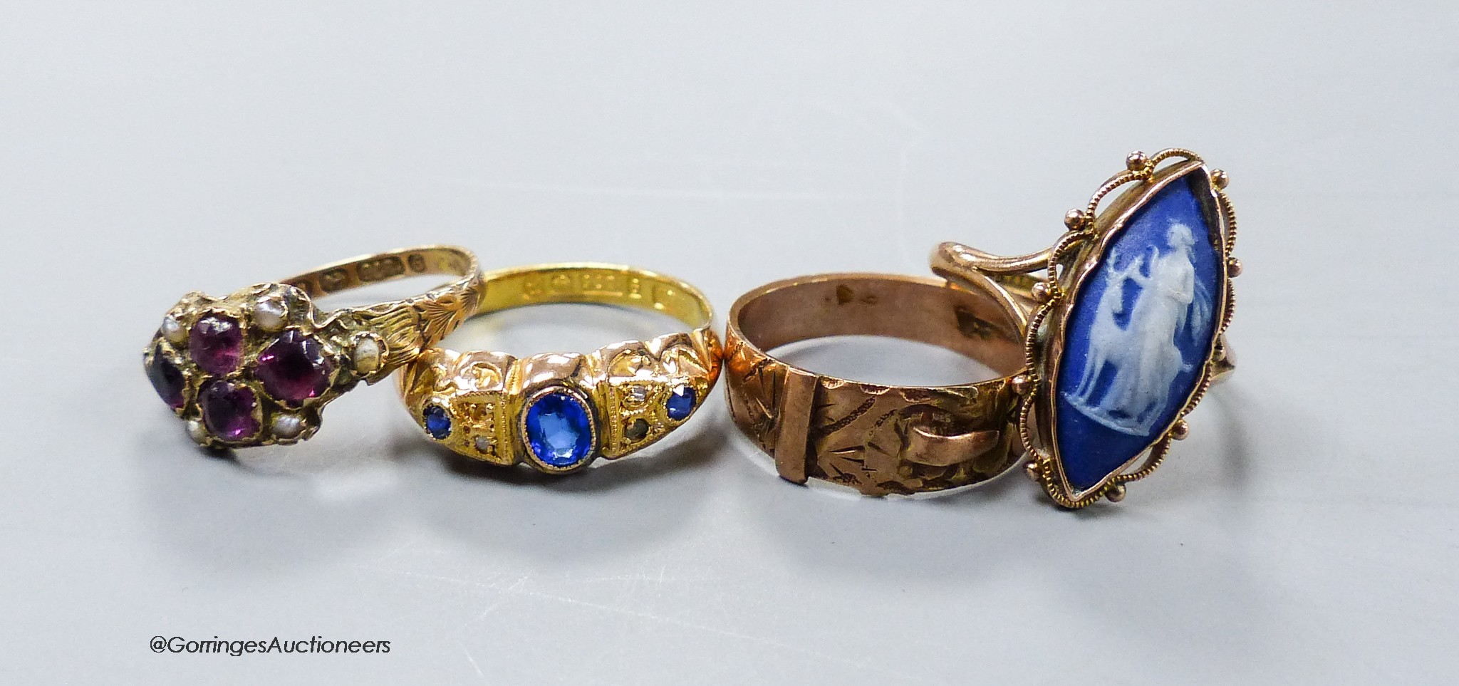 A late Victorian 9ct gold, amethyst and seed pearl cluster set dress ring and three other early 20th century 9ct gold gem set rings including a buckle ring, gross 8.6 grams.